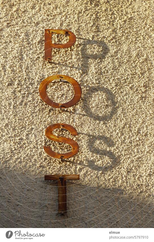 POST is written vertically in rusting letters and casting shadows on a building Mail Post office Post office building dilapidated Rust rusty Nostalgia