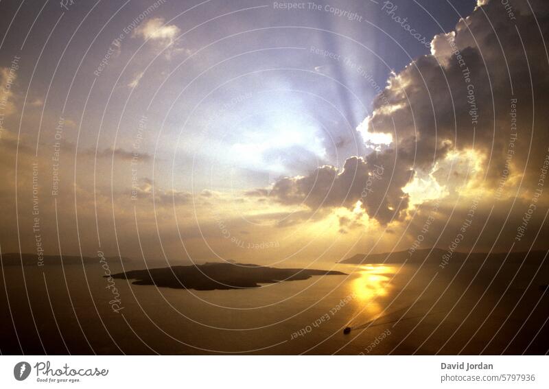 beautiful play of light - sun with clouds - over the sea Sunset over the sea with clouds Dark clouds over the sea Island under clouds with rays of sunshine