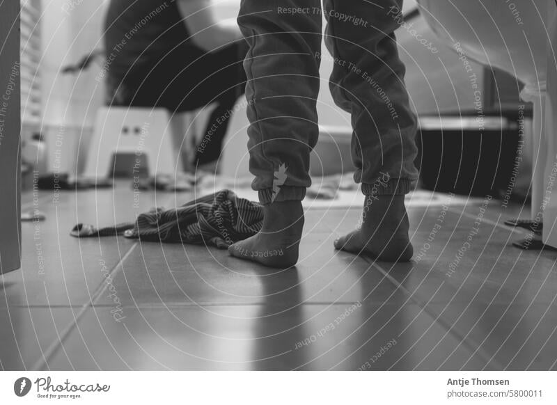 Children's feet on tiles in the bathroom with a person sitting on a stool in the background Children's foot Barefoot barefoot Bath time Feet Infancy Detail Life