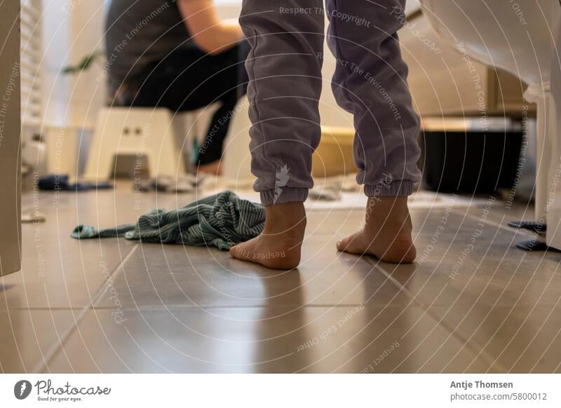 Children's feet on tiles in the bathroom with a person sitting on a stool in the background Children's foot Barefoot barefoot Bath time Feet Infancy Detail Life