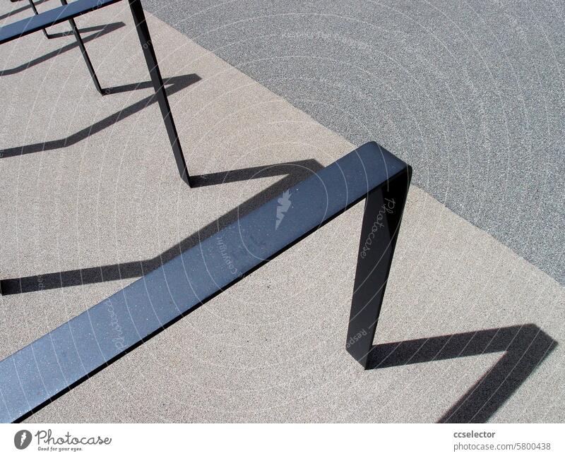 A bicycle stand casts shadows on a gray concrete floor shadow cast Sunlight Light Light and shadow Silhouette Shadow play Abstract natural light daylight