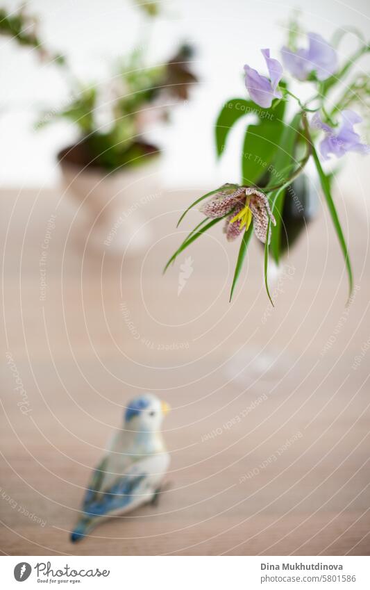 Fritillaria meleagris spring flower closeup on white background aesthetic floral image in glass and ceramic bird figurine flowers purple lilac blossom Violet