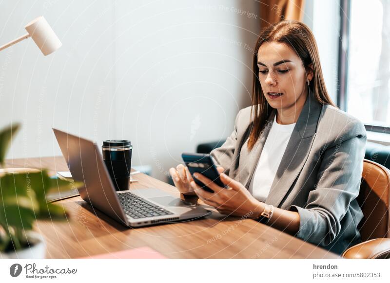 woman in the office using her smartphone businesswoman mobile phone telephone smart phone technology device message reading working indoor cellphone