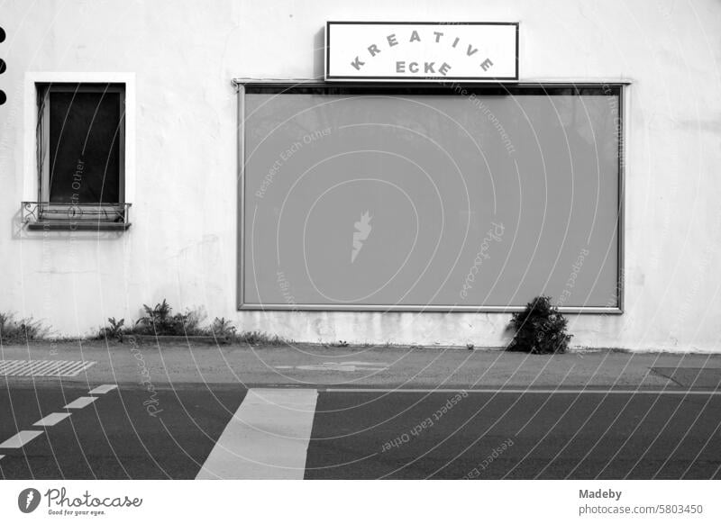 Creative corner with taped-up shop window and crosswalk in the district of Pivitsheide in the province near Lage and Detmold in the Teutoburg Forest in East Westphalia-Lippe in neo-realistic black and white