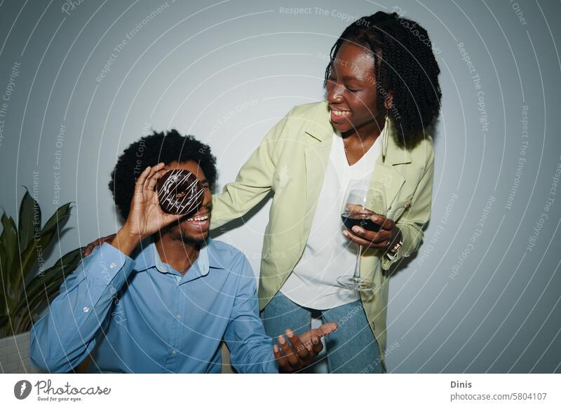 Cheerful coworkers having wine and donuts in office Party doughnut playful happy celebrate Friday businesswoman colleague black man Businessman people career