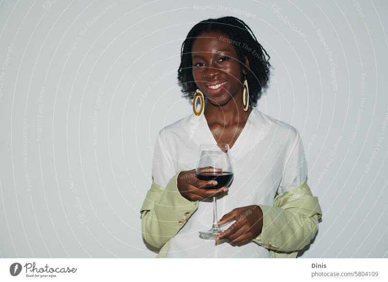 Portrait of smiling Black woman with glass of red wine drink Party portrait office celebrate Friday businesswoman workplace alcohol positive smile flash excited