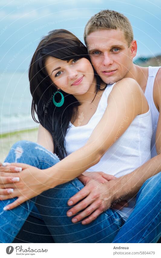 guy and a girl in jeans and white t-shirts on the beach walk along the coast sea joy ocean blue T-shirt summer water sky together couple sand clay