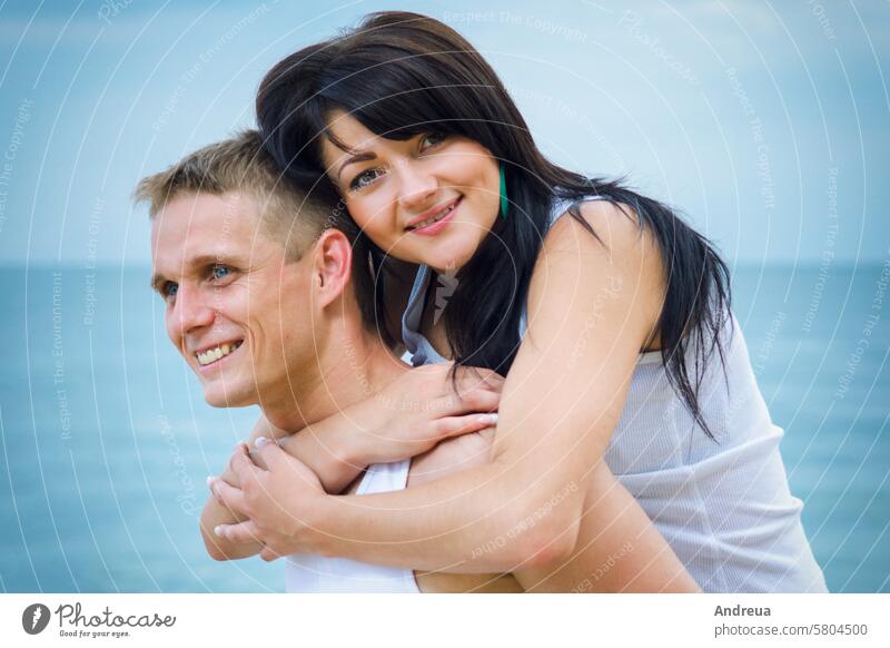 guy and a girl in jeans and white t-shirts on the beach walk along the coast sea joy ocean blue T-shirt summer water sky together couple sand clay