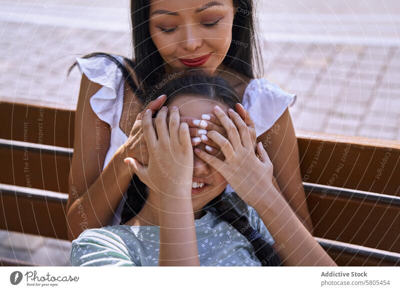 Girl with autism spectrum having fun with her mother on a bench in the city Woman female daughter child person with autism ADHD neurodiversity childhood kid