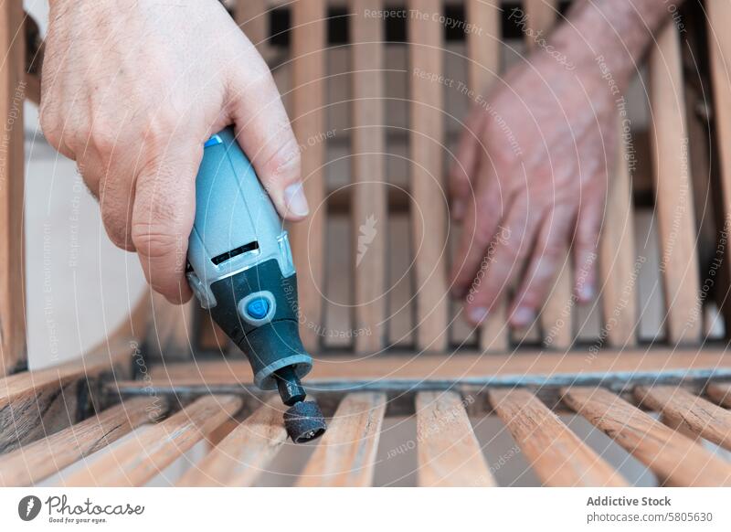 Close-up of a Man Sanding Wooden Furniture Outdoors man sanding wooden furniture outdoors power sander bench sawdust work diy woodworking restoring wood surface