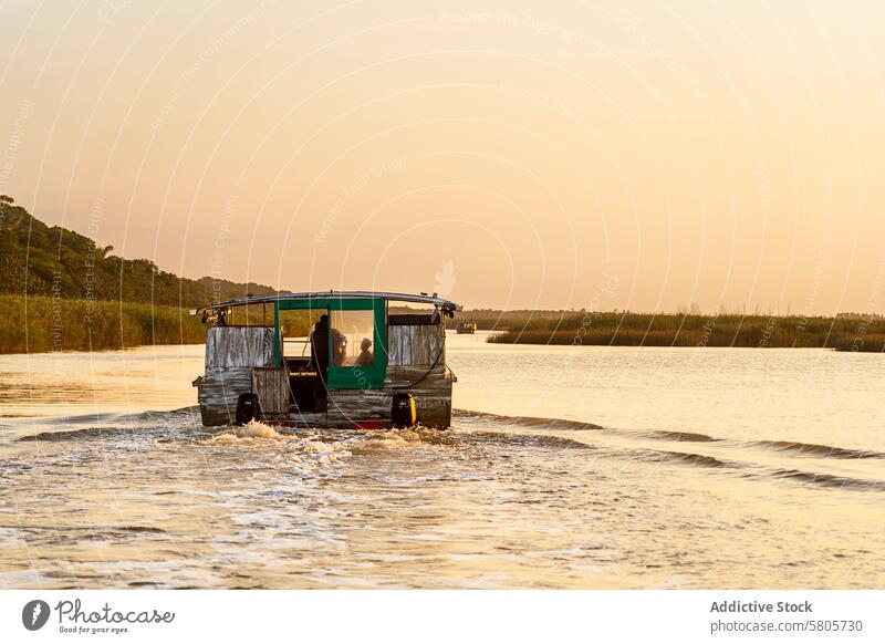 Sunset voyage on a tranquil South African lake boat sunset water reflection warm hues serene south africa navigation rustic calm waters african landscape travel