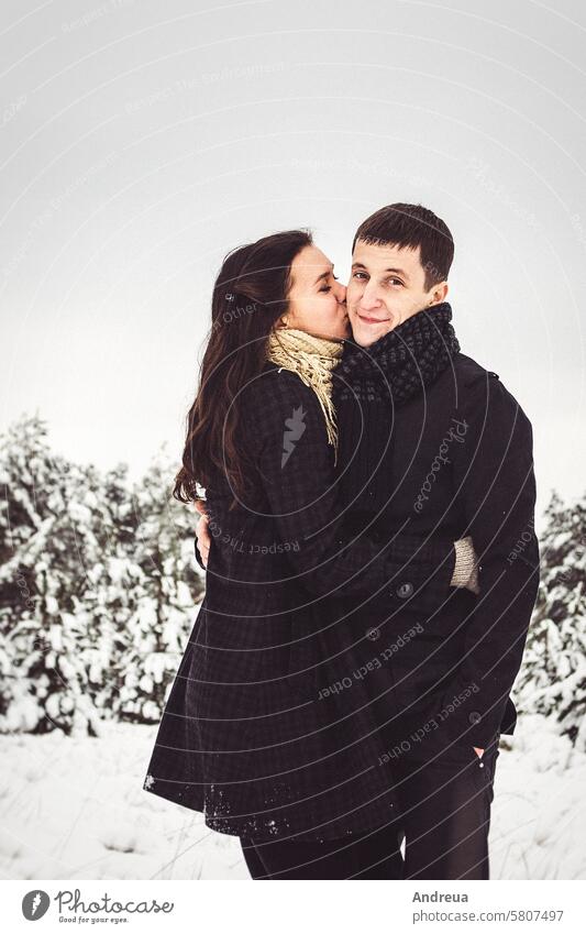 A guy and a girl in warm clothes and scarves on a walk in the snowy weather black coat cold fall field nature new year romance scarf together wet white winter