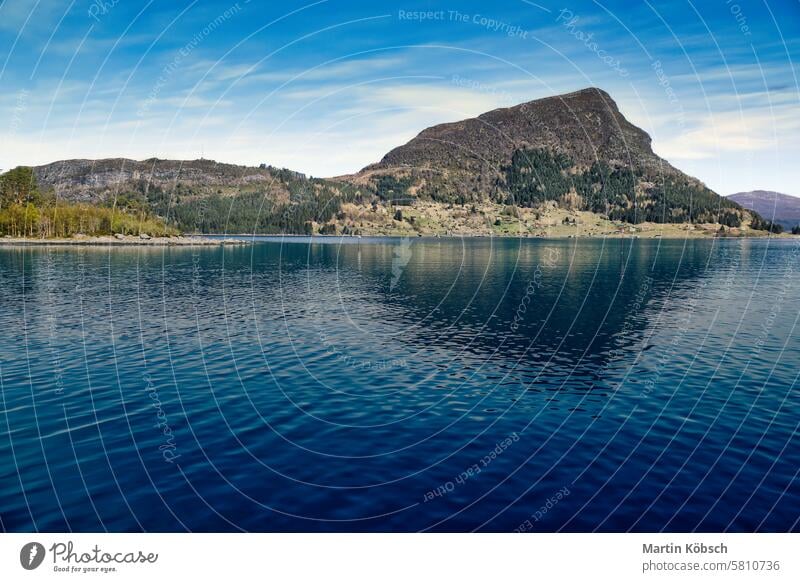 Island with rocks and trees in the fjord in front of the open sea in Norway. Fjord sunset mountain wilderness nature nordic panorama romantic fresh water sky