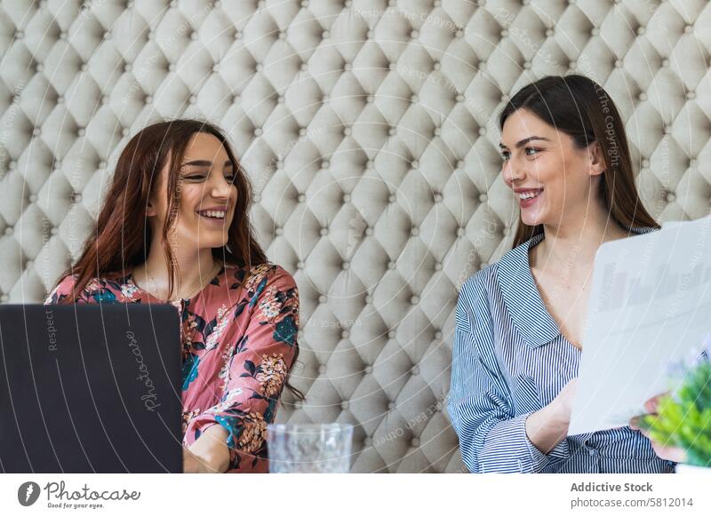 Focused women working on laptops in coworking space paperwork focus office workplace colleague busy workspace teamwork coworker professional browsing gadget