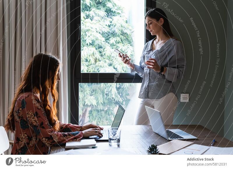 Positive colleagues working on laptop in light workspace take note write team positive content office workplace student coworker teamwork exam preparation