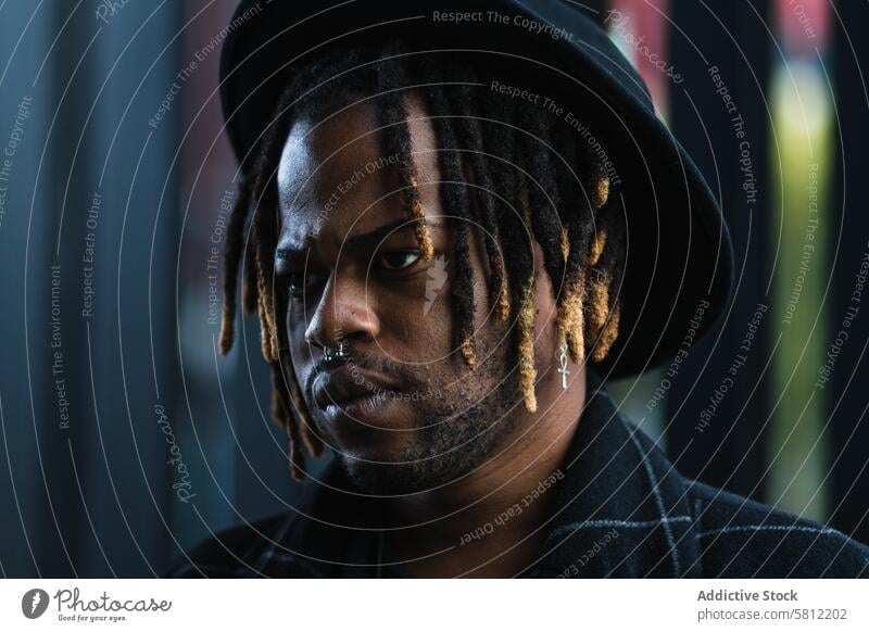 Brutal black guy in hat on street cool brutal street style man dreadlocks informal urban lifestyle confident rebel trendy appearance posture cityscape culture