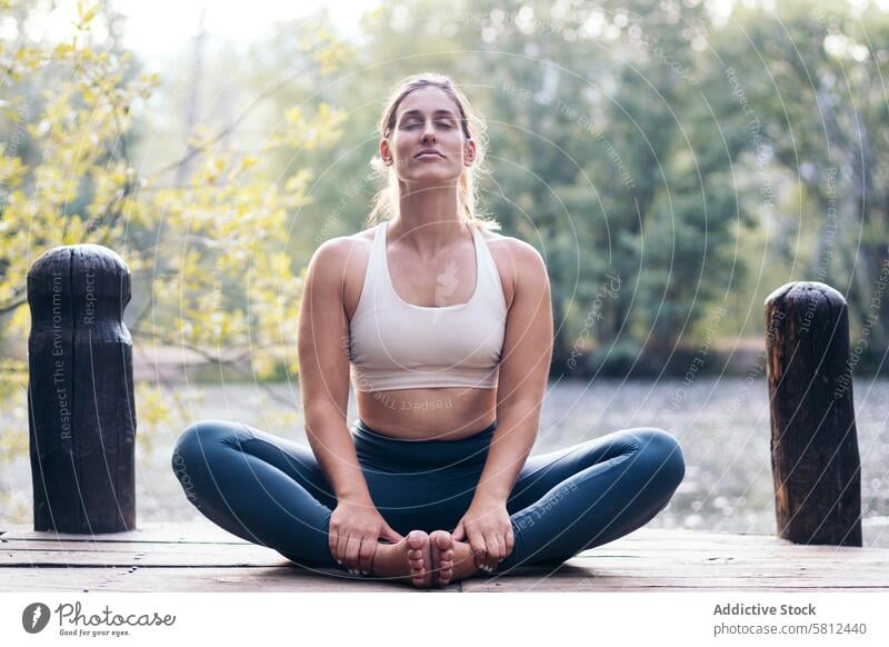 woman meditating in nature near a lake yoga meditation healthy relaxation body adult pose lifestyle balance exercise young person concentration zen peaceful fit