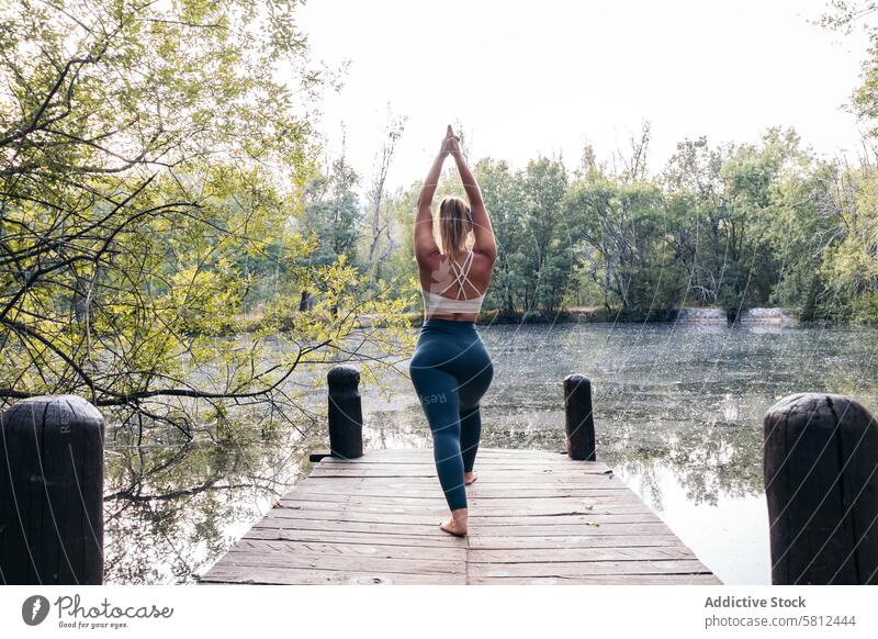 woman in sportswear doing yoga in nature near a lake healthy exercise lifestyle fitness body workout caucasian training pilates young wellness activity active