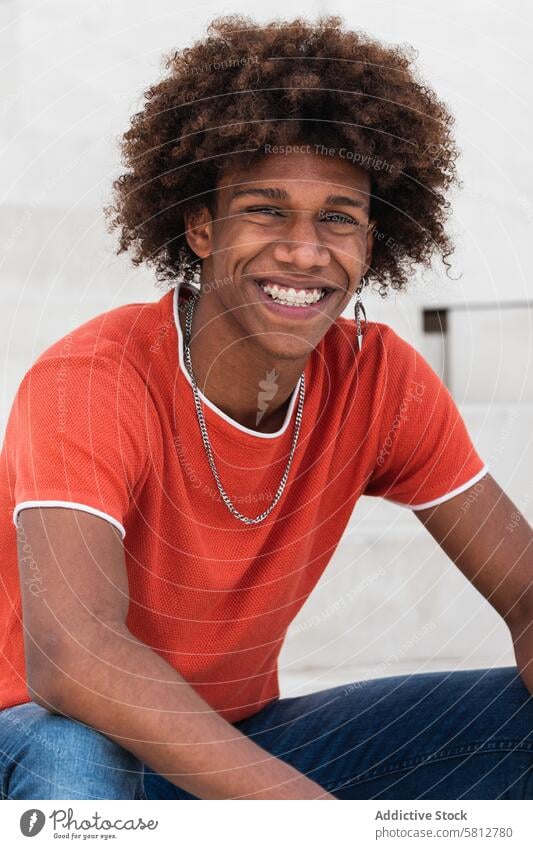 Positive young black male smiling at camera while chilling on street man smile style charismatic personality millennial urban appearance self assured positive