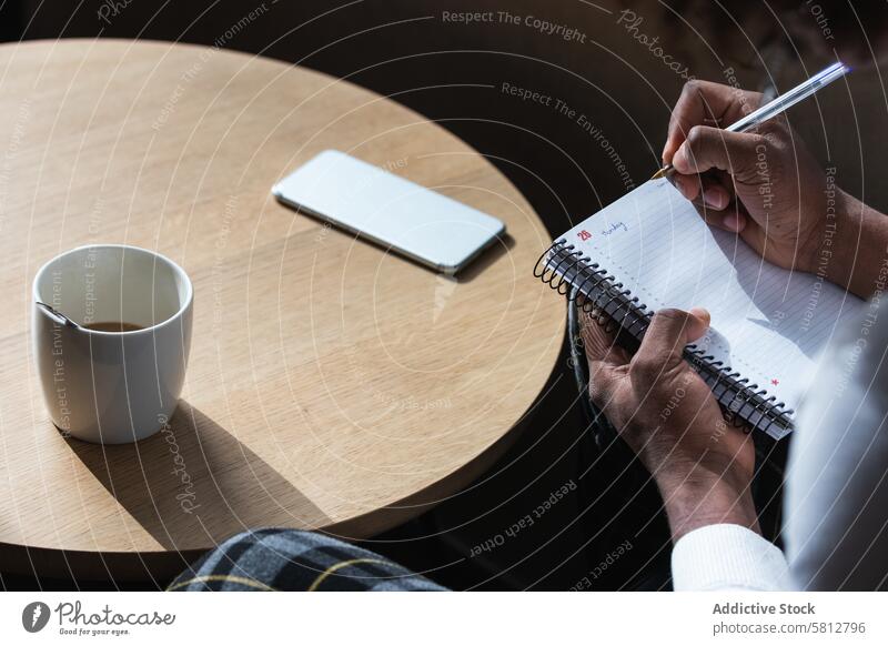 Trendy young black guy doing assignment in cafe man take note exam preparation confident style smart fashion coffee education serious concentrate