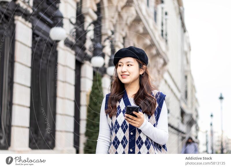 Young Asian Woman Walking and Using Smartphone in the City asian people street city young happy lifestyle walking fun outdoors women urban female cheerful