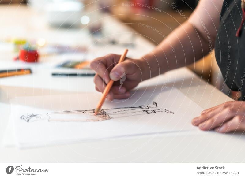 Close-up of a fashion designer drawing a fashion sketch. 50s above clothing confidence confident creativity desk directly above dressmaker empowerment