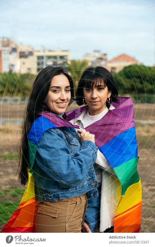 Pride celebration with joyful LGBTQ friends lgbtq pride flag rainbow smile camera acceptance couple friendship diversity union support equality community