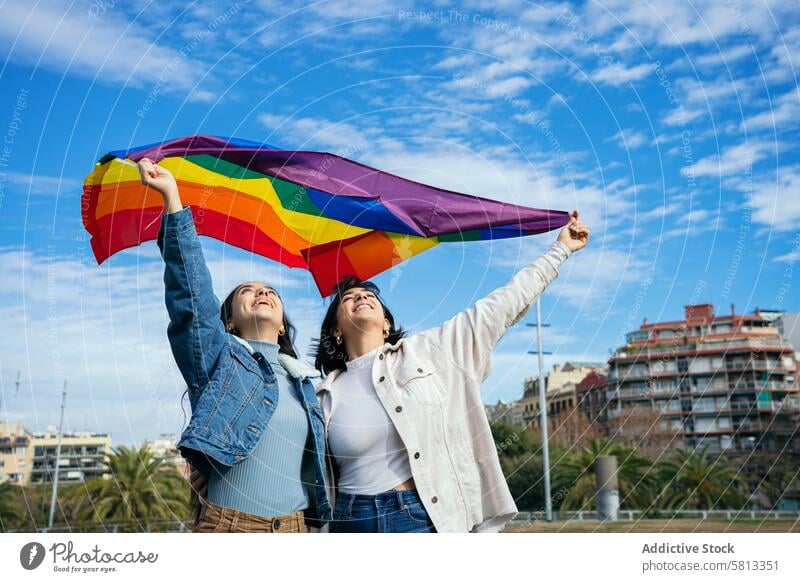 Celebrating Diversity with Pride Flag under Blue Sky pride flag lgbtq+ friends celebration diversity joy blue sky freedom community support happiness