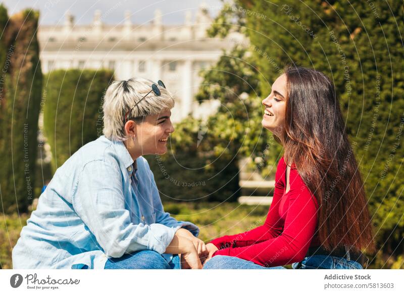 two young girls sitting talking people friendship casual lifestyle female happy together conversation adult cheerful woman communication beautiful caucasian