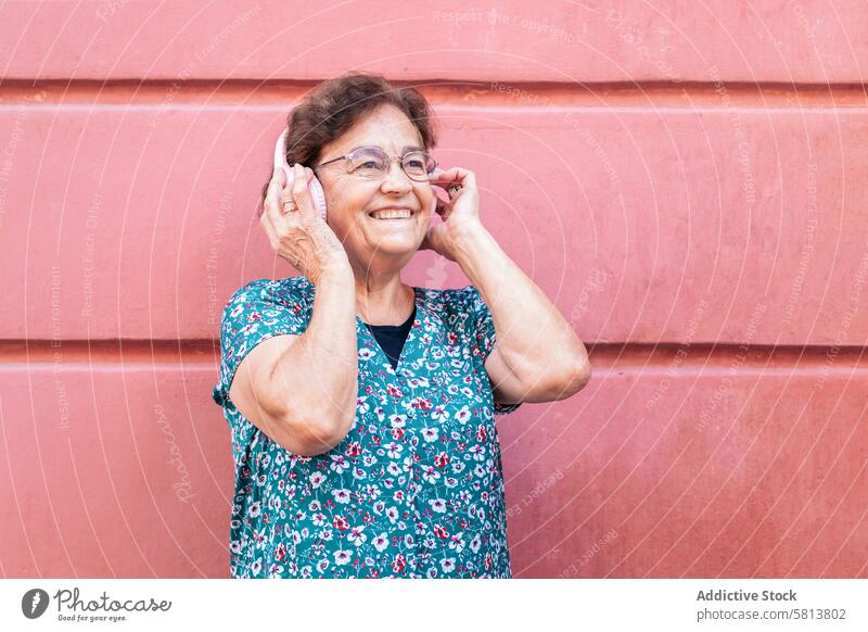 Senior woman in colorful clothes and modern headphones stylish senior female lifestyle old people businesswoman caucasian technology happy lady elder smile