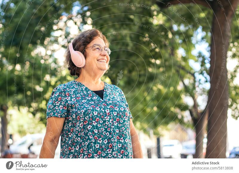 Senior woman walking down the street listening to music stylish senior female lifestyle old people businesswoman caucasian technology happy lady elder smile