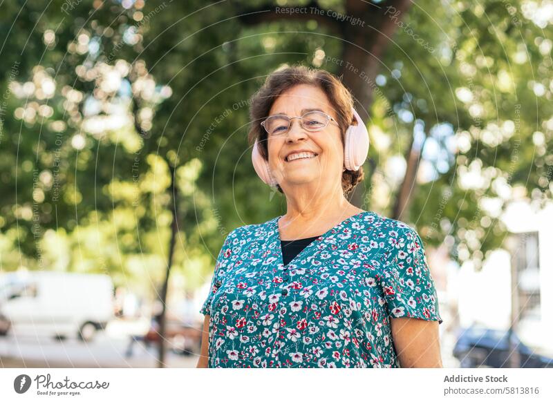 Senior woman walking down the street listening to music stylish senior female lifestyle old people businesswoman caucasian technology happy lady elder smile