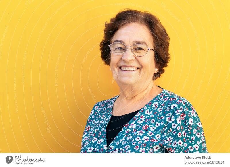 Cheerful old woman on yellow background stylish senior female lifestyle people caucasian happy lady elder smile confident leisure grandma expression cheerful