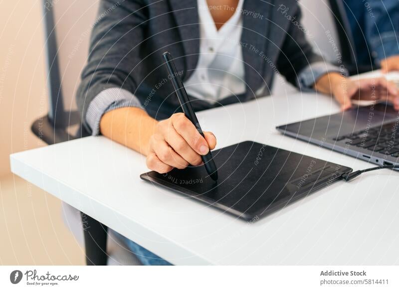 Close-up of an unrecognizable woman using a graphics tablet in an office analysis business company company data coworking worker remote work Shared office