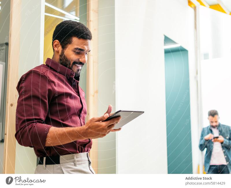 Smiling man in shirt working with a tablet in a coworking business worker lifestyle manager businessman professional modern internet office technology