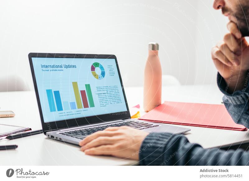 Close-up of a man analyzing company data on a laptop analysis business office coworking worker graphics remote work Shared office Productivity Collaboration