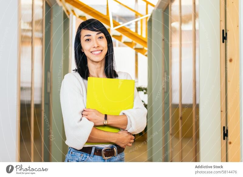 Portrait of smiling Asian woman looking at camera holding folder in modern office businesswoman worker lifestyle manager professional coworking confidence