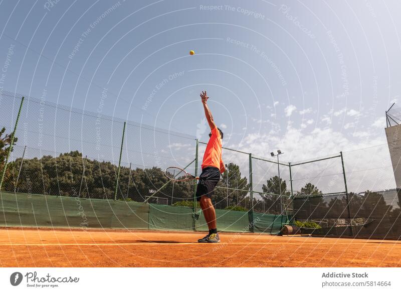 Man in sportswear playing tennis on a dirt tennis court activity game racket person player athlete training lifestyle healthy exercise ball happy athletic hobby