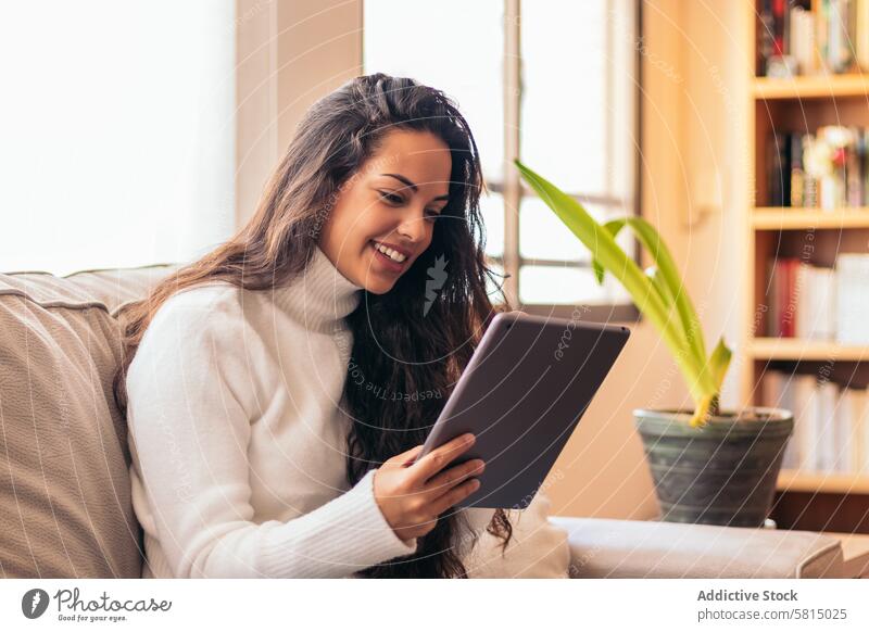 Connected Youth: A Young Woman Using a Tablet at Home Technology Digital lifestyle Online communication Internet connection Social media Wi-Fi Touch screen