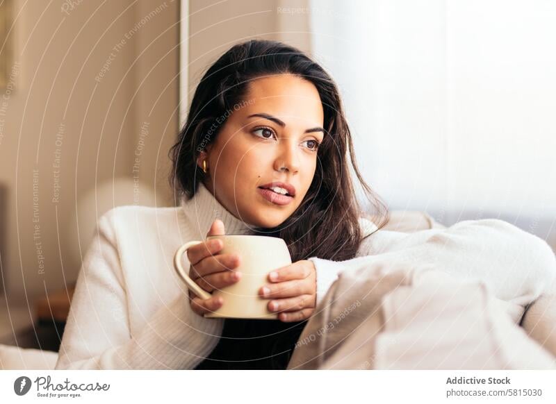 Enjoying Morning at Home: Young Woman Drinking Coffee Relaxation Window Sofa Indoors Cozy Serene Tranquility Comfort Peaceful Lifestyle Contentment Leisure