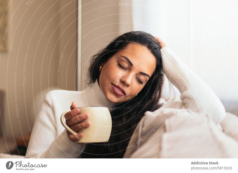 Enjoying Morning at Home: Young Woman Drinking Coffee Relaxation Window Sofa Indoors Cozy Serene Tranquility Comfort Peaceful Lifestyle Contentment Leisure