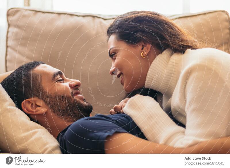 Romantic stock photo of young couple on sofa at home romance love cozy intimate relationship together happiness comfort togetherness affection bonding