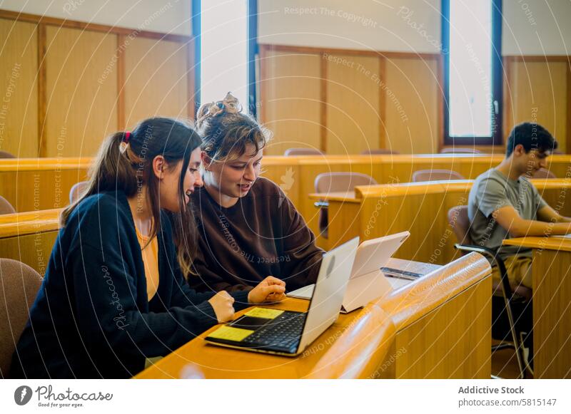 Team of woman students sitting at desk with laptop and tablet women study education discuss smile communicate classroom young female netbook computer browsing