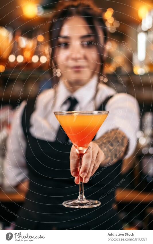 Young female bartender offering a drink cocktail barwoman beverage mixologist nightclub alcohol barkeeper glass work professional bartending indoors jigger job