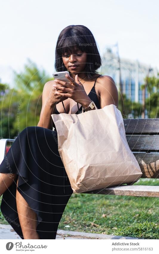 Serious black woman messaging on smartphone serious surfing using texting message shopper social media elegant female gadget browsing connection internet