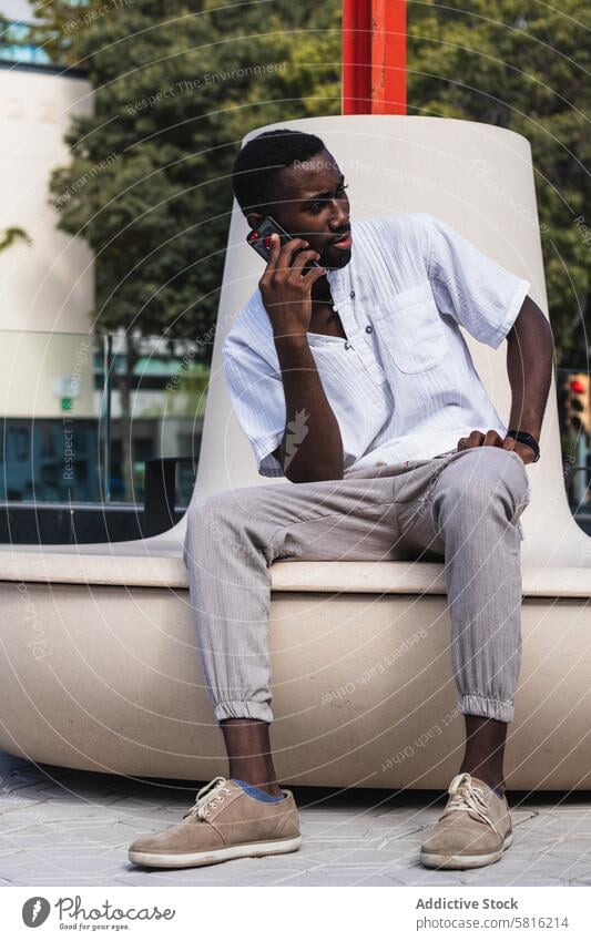 Black man talking on smartphone in city speak street busy freelance discuss project male ethnic black african american mobile communicate using cellphone gadget