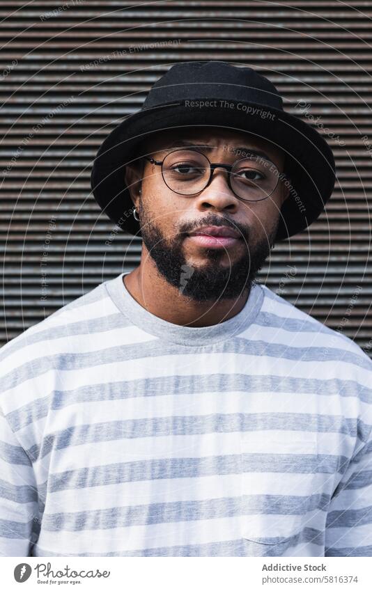 Back hipster man in hat looking at camera trendy smile beard eyeglasses optimist male african american black ethnic outfit style positive joy lifestyle glad