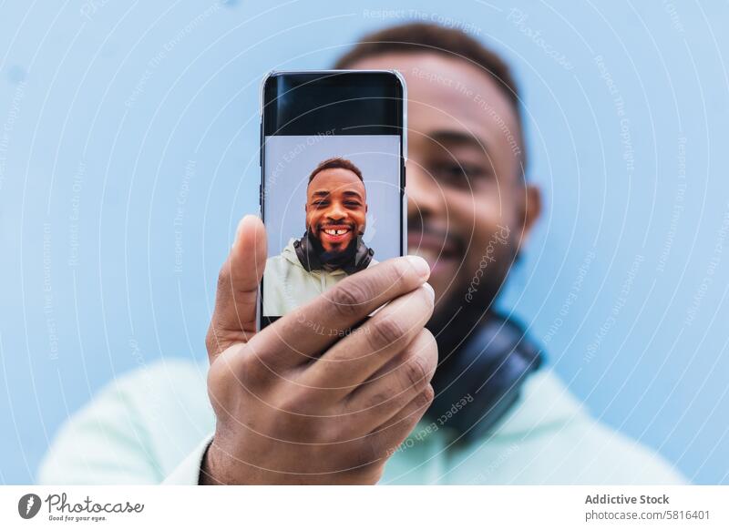 Happy ethnic man taking selfie on smartphone happy hipster cheerful mobile photography using take photo adult black african american male casual device gadget