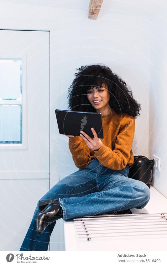 Black woman with tablet on counter using kitchen online chill at home free time relax internet female portrait black african american browsing gadget young