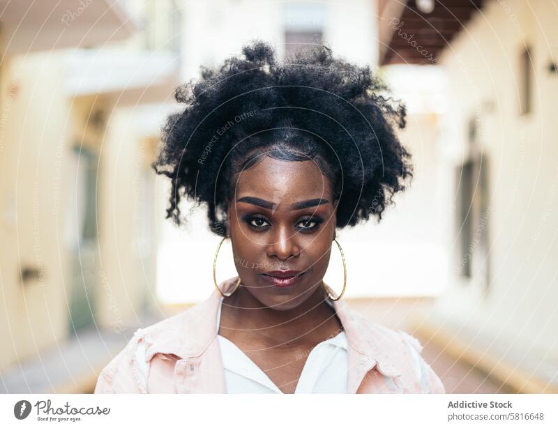 Portrait of a pretty black woman with afro hair street city young female outdoors urban fashion beautiful lifestyle casual people attractive curly portrait